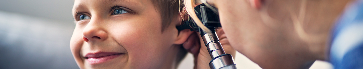 A doctor examines a child's ear with an otoscope